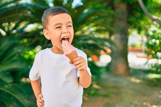 Adorable hispanic boy smiling happy eating ice cream at the park.