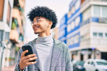 Young african american businessman smiling happy  using smartphone at the city.