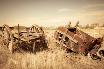old rusty vintage Farm Equipment - old chariot and an old hay baler