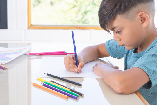 Profile photograph of a boy doing his homework at home