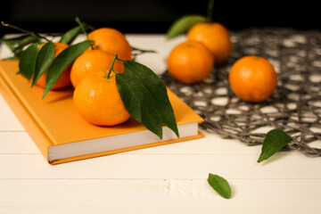 mandarine and orange book on a wooden table, orange color is  mood boosters