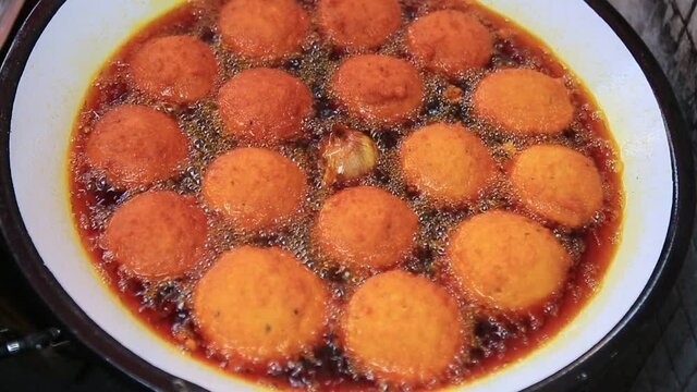 salvador, bahia, brazil - january 8, 2021: acaraje during frying in a pan with palm oil, in downtown Salvador.