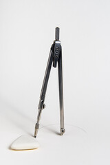 Compass for sketching and eraser on white paper