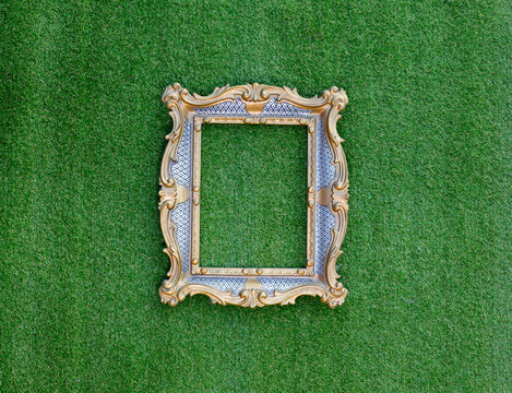 golden elegant victorian frame on green grass