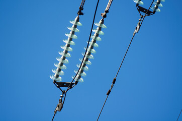 Obraz premium Electric line with insulators against blue sky