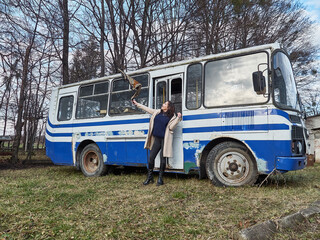 Beautiful girl with a headscarf posing on the background of an old broken bus