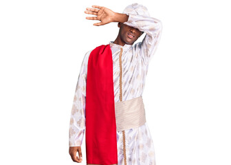 African handsome man wearing tradition sherwani saree clothes covering eyes with arm, looking serious and sad. sightless, hiding and rejection concept