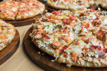 Pizza in plates on wooden table.