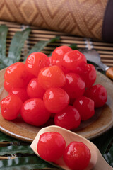 Bright red candied cherries in a brown plate