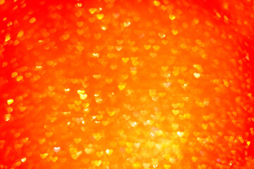 Blurred out of focus bokeh background. Texture from red orange hearts. Preparation for a holiday greeting card. Abstract valentines day, festive love. Place for text, copy space. Pattern sunset of sun