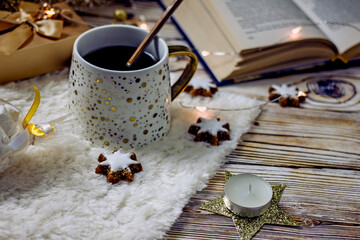Hygge style. White and gold mug of tea on a wooden table, copy space. Cozy tea party