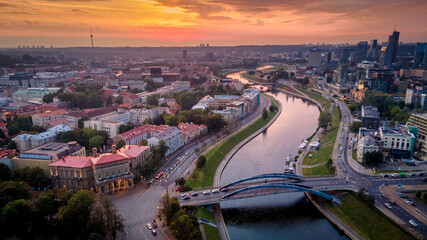 Aerial view of Vilnius panorama during sunset on two sides of river Neris by drone