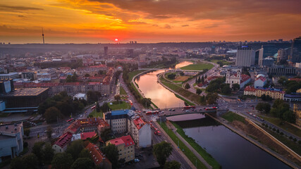 Aerial view of Vilnius panorama during sunset on two sides of river Neris by drone