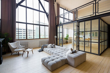 trendy modern design two-level apartment with large high windows. The stylish living room and...