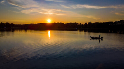 Aerial view of sunset with fisherman near lake Margis by drone