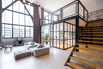 trendy modern design two-level apartment with large high windows. The stylish living room and...