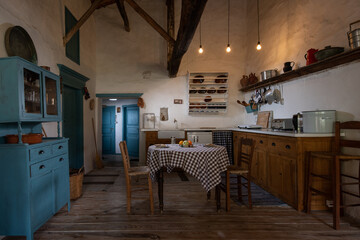 Traditional interior of old village kitchen in historic country house with stucco walls, wooden...