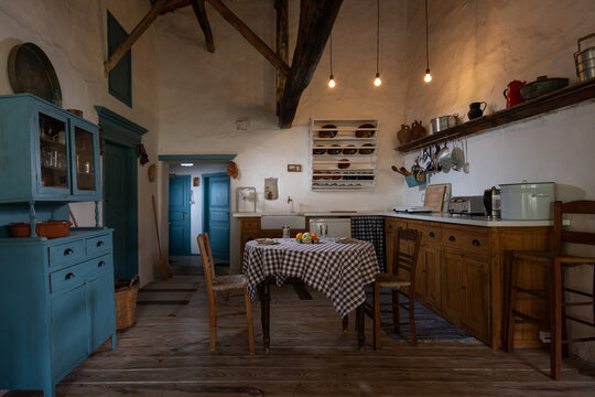 Traditional Interior Of Old Village Kitchen In Historic Country House With Stucco Walls, Wooden Beams, Oak Wood Furniture, Vintage Kitchenware