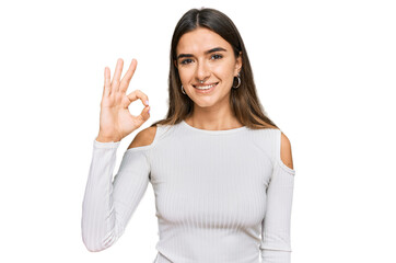 Obraz premium Young hispanic woman wearing casual clothes smiling positive doing ok sign with hand and fingers. successful expression.