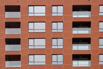 terracotta modern facade of the house with windows and loggias