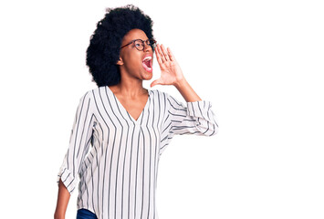 Young african american woman wearing casual clothes and glasses shouting and screaming loud to side with hand on mouth. communication concept.