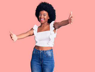 Young african american woman wearing casual clothes looking at the camera smiling with open arms for hug. cheerful expression embracing happiness.