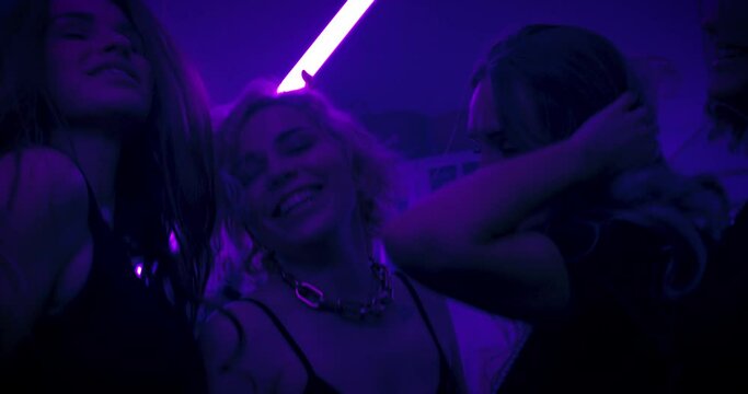 Best friends dance at a home-made party with disco lights