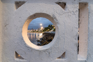Night view of the beach edge of the city of Santos through the span of the wall that is a landmark of the city.