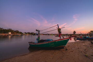 Fototapeta premium Beautiful twilight sunset sky at pier and estuary with lot of fisherman ships
