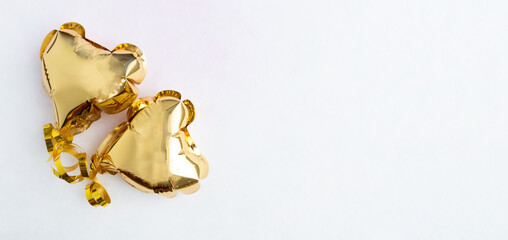 Two gold hearts, foil balloons top view on a white background. Valentine's day, banner, postcard.