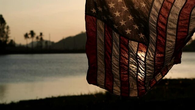 Happy Memorial Day. American flag waving on sunset or sunrise background with soft focus, Slow Motion. Concept of Memorial Day or 4th of July, Independence Day, Veterans Day, American Election