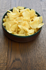 Large wood bowl of crispy Kettle potato chip snack on hardwood planks
