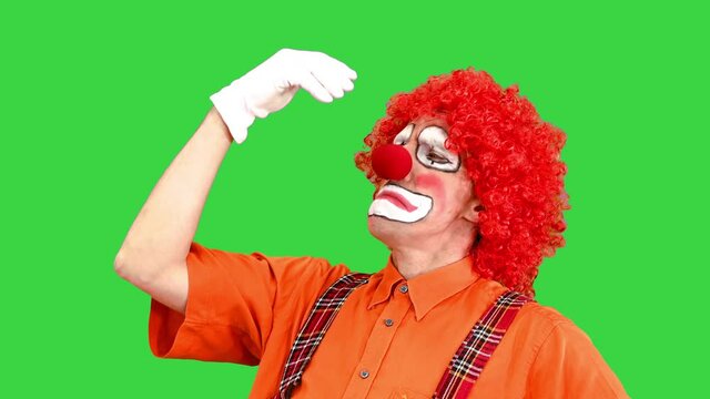 Funny clown taking different poses while thinking and like the thinker of Rodin as well on a Green Screen, Chroma Key.