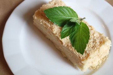 Cake on a white plate decorated with mint leaves