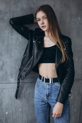 Stylish girl portrait. Young caucasian pretty beautiful slim girl isolated on grey background