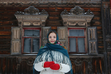 Russian woman, girl. Pogorelovo terem. Wooden house with carved windows, ornamental frames in...