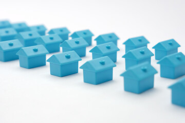 Real estate in cottage village. Home owner association. Rows toy houses. Miniature blue houses arranged in three rows. Miniature toy buildings. Many small houses. Miniature homes with property market