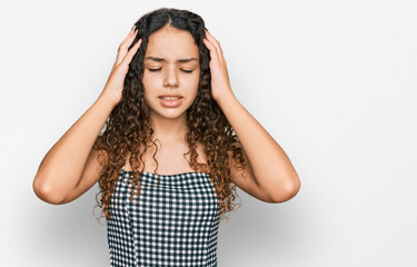 Teenager hispanic girl wearing casual clothes with hand on head for pain in head because stress. suffering migraine.