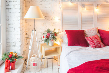 A spacious white light bedroom in a loft style with a decorated Christmas tree and a garland.
