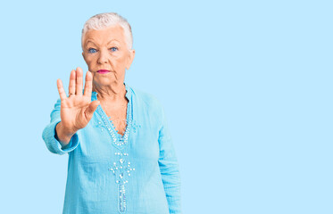 Senior beautiful woman with blue eyes and grey hair wearing summer dress doing stop sing with palm of the hand. warning expression with negative and serious gesture on the face.