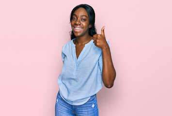 Young african american woman wearing casual clothes smiling happy and positive, thumb up doing excellent and approval sign