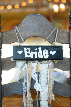 Brown Bride and groom chairs at wedding recetion sweetheart tablewith bokeh backgrounds
