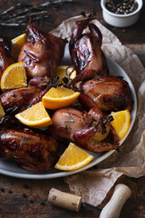 Festive dish with grilled quail and oranges. Vertical image