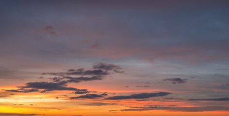 Natural color dramatic dawn or dusk sky with painterly yellow, pink and blue clouds with horizon, taken with wide angle 35 mm lens for sky replacement