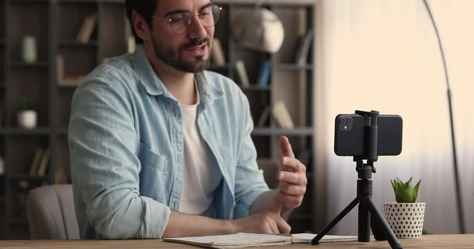 Man put smartphone on stabilizer talk to camera recording vlog share knowledge with auditory, film commercial motivational video. Streaming communication podcast activity, remote consultation concept