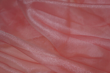 Silk fabric, shiny organza is light pink or peach color as background. Wedding decorate concept. ...