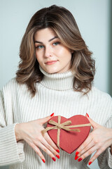 Beautiful girl open red heart gift box. Valentine's day. Happy Birthday.  Girl receives a gift at home.