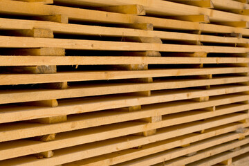 thick wooden boards stacked to dry
