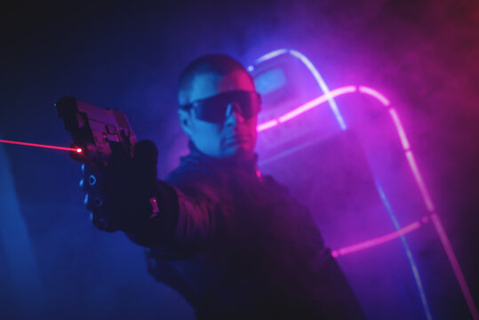 Futuristic soldier in the neon lights with the rifle.