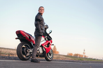 Obraz na płótnie Canvas Motor biker is standing on the road.